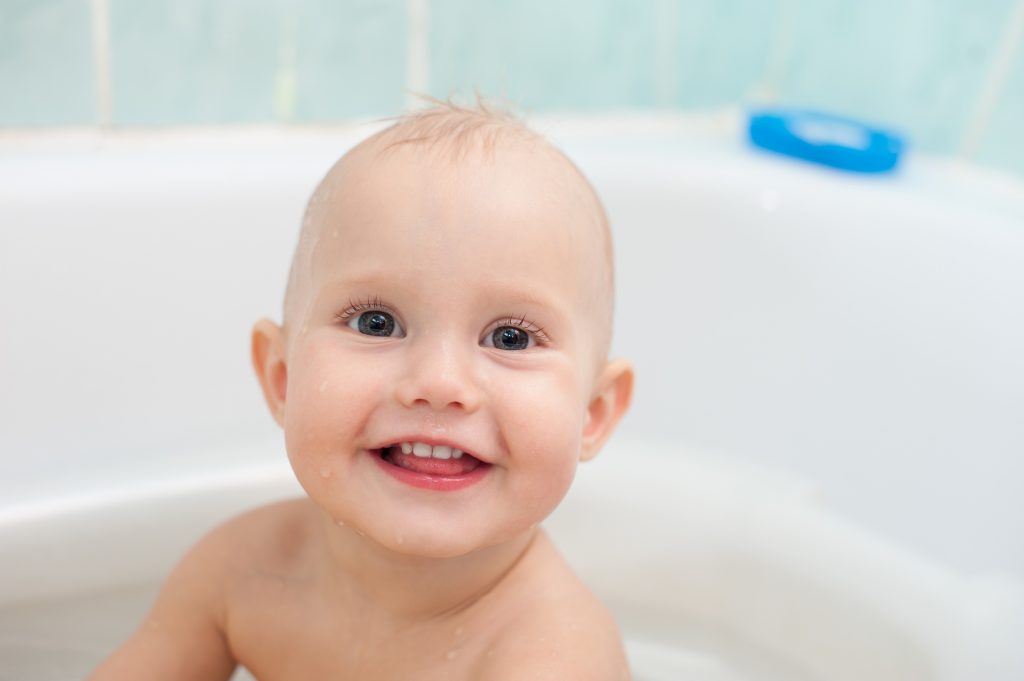 Happy little kid taking a bath